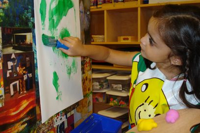 Preschool aged girl painting.