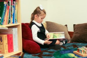 little girl reading in a nook