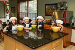 children in a kitchen dressed as chefs